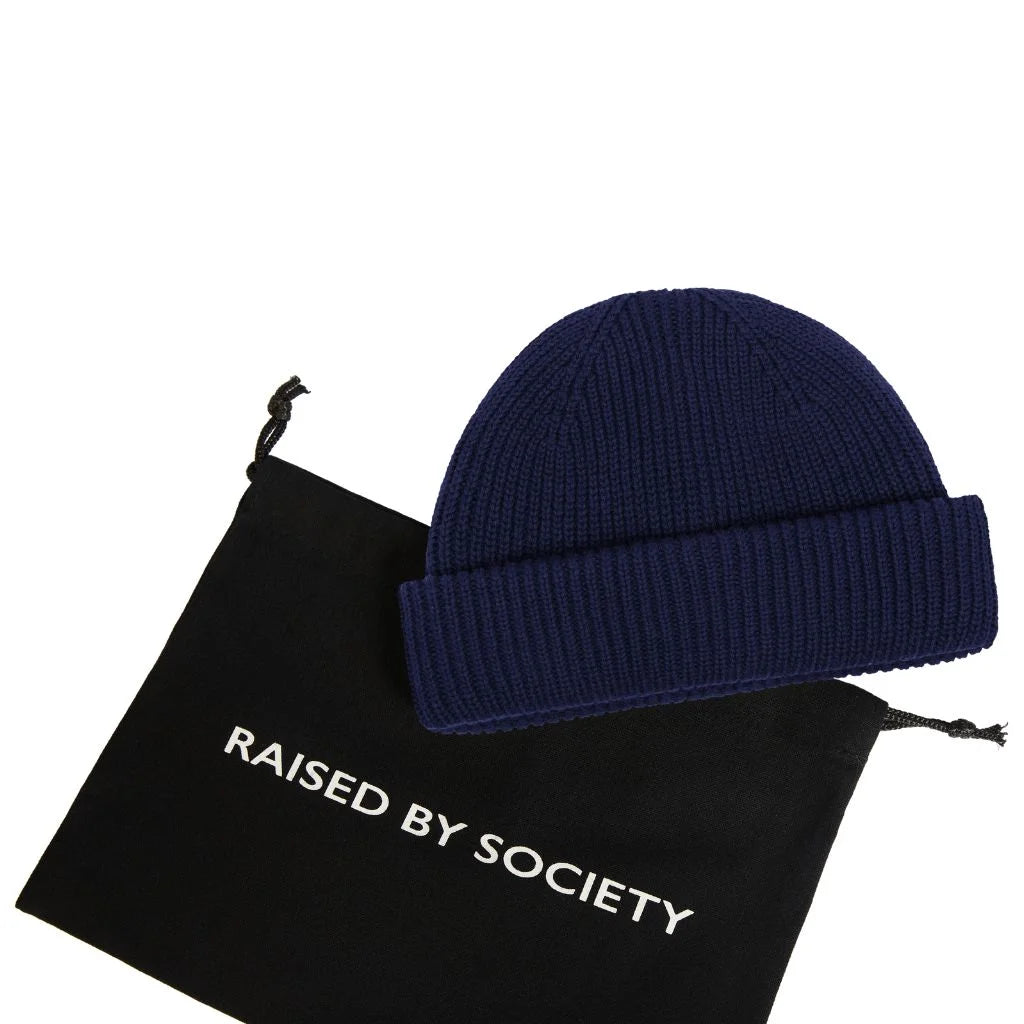 Cuffed fisherman beanie cotton. Black bag  with RAISED BY SOCIETY logo branding beneath the beanie.