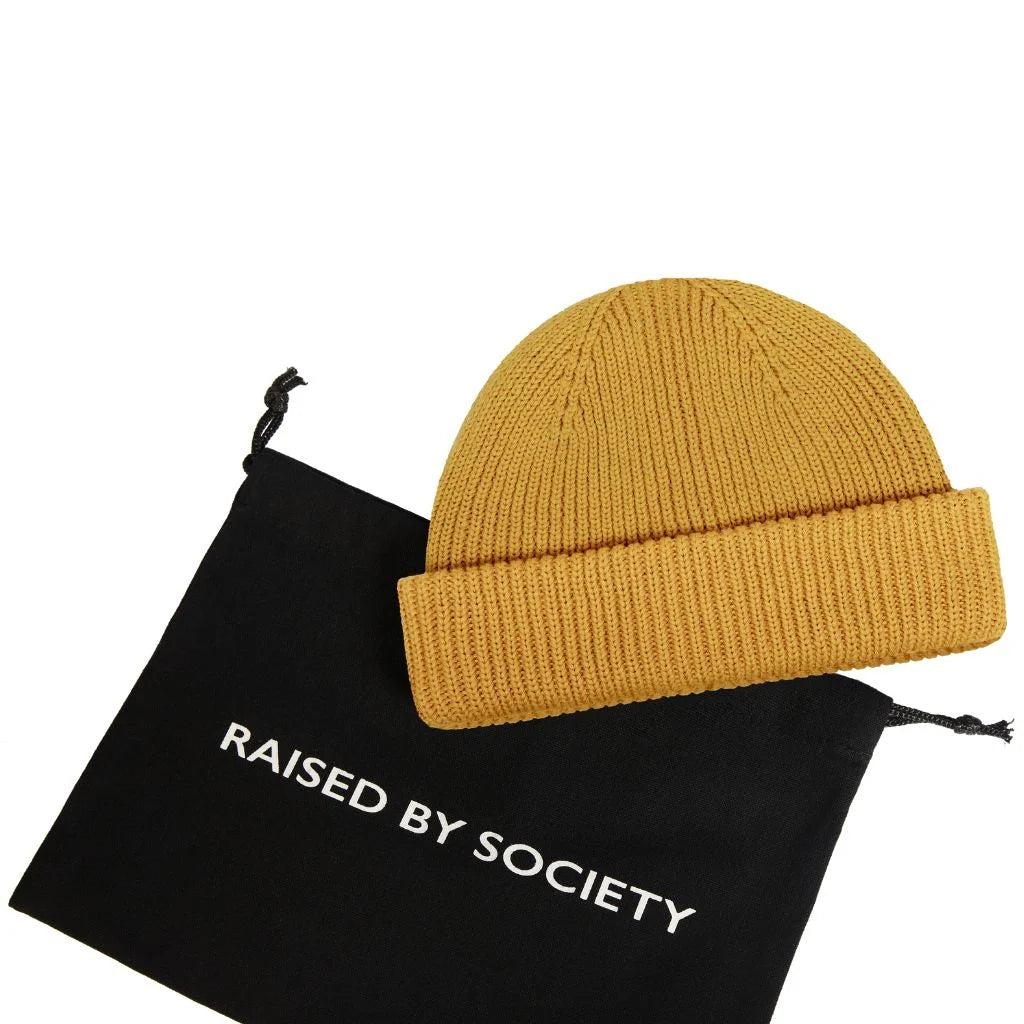 Classic fisherman beanie cotton. Mustard yellow with black carry bag. RAISED BY SOCIETY logo on the bag. Perfect for gifting. 