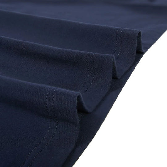 Close-up of folded navy blue fabric with visible stitching, shown against a white background.