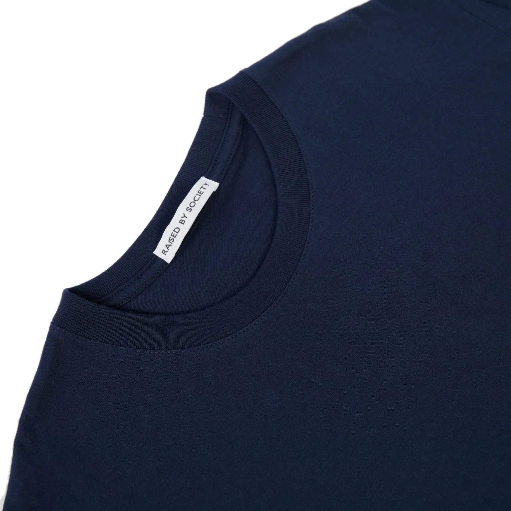 Close-up of a navy blue loopwheeled crewneck t-shirt showing the inner neck label which reads 'RAISED BY SOCIETY'.